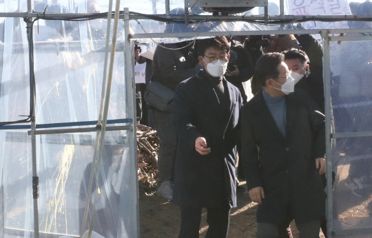 13일 이재명 더불어민주당 대선 후보가 경북 성주군 다정농원을 찾아 성주 참외 모종 심기 체험을 하기 위해 비닐하우스에 들어서다가 현장에 있던 한 고교생이 계란을 투척한 방향을 응시하고 있다. 사진 왼편 비닐하우스 문에 계란이 묻어 있는 것이 확인된다. 연합뉴스.